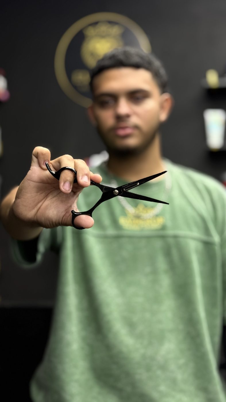Barbero acercando la tijera a la cámara